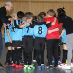 Kinder-Fußballteam im Kreis mit Trainern motiviert