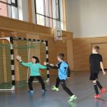 Kinder spielen Fußball in der Sporthalle