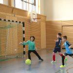 Kinder spielen Hallenfußball in einer Sporthalle
