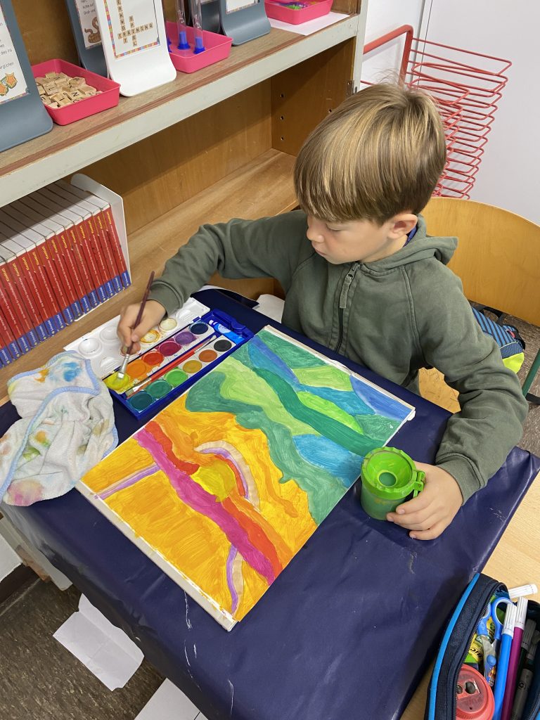Kind malt farbenfrohes Bild in der Schule