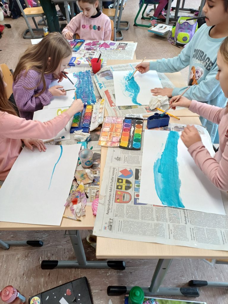 Kinder malen im Kunstunterricht mit Wasserfarben.
