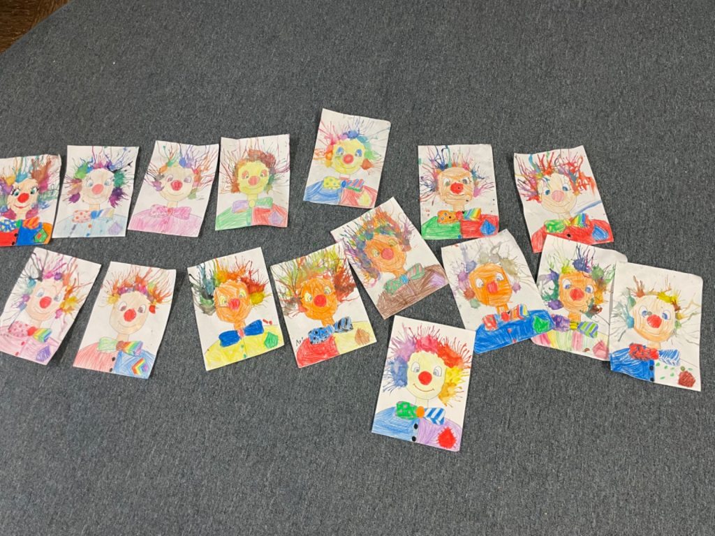 Bunte Kinderzeichnungen von Clowns auf grauem Hintergrund