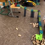 Kinder bauen eine kreative Domino-Struktur im Klassenraum