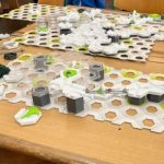 Komplexes Strategiespiel auf einem Holztisch platziert.