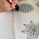 Hand zeichnet geometrische Muster auf weißem Papier