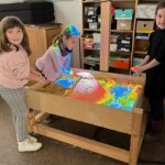 Kinder spielen mit buntem Sand im Klassenzimmer