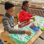 Kinder malen mit Wasserfarben im Klassenzimmer kreativ