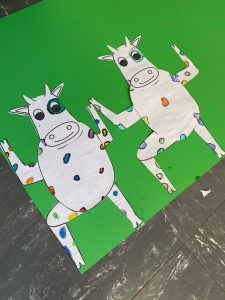 Bunte Kuhzeichnungen auf grünem Hintergrund Kunstprojekt