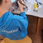 Junge bastelt kreativ an einem Tischprojekt.