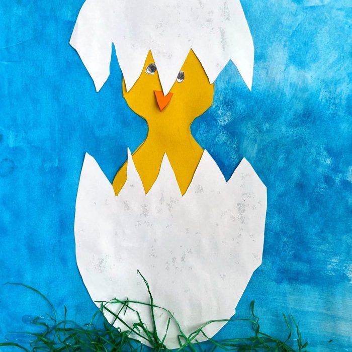 Küken schlüpft aus Ei auf blauem Hintergrund