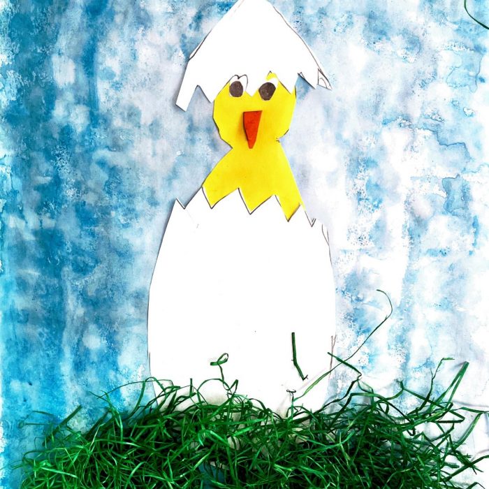 Küken schlüpft aus Ei auf grünem Gras